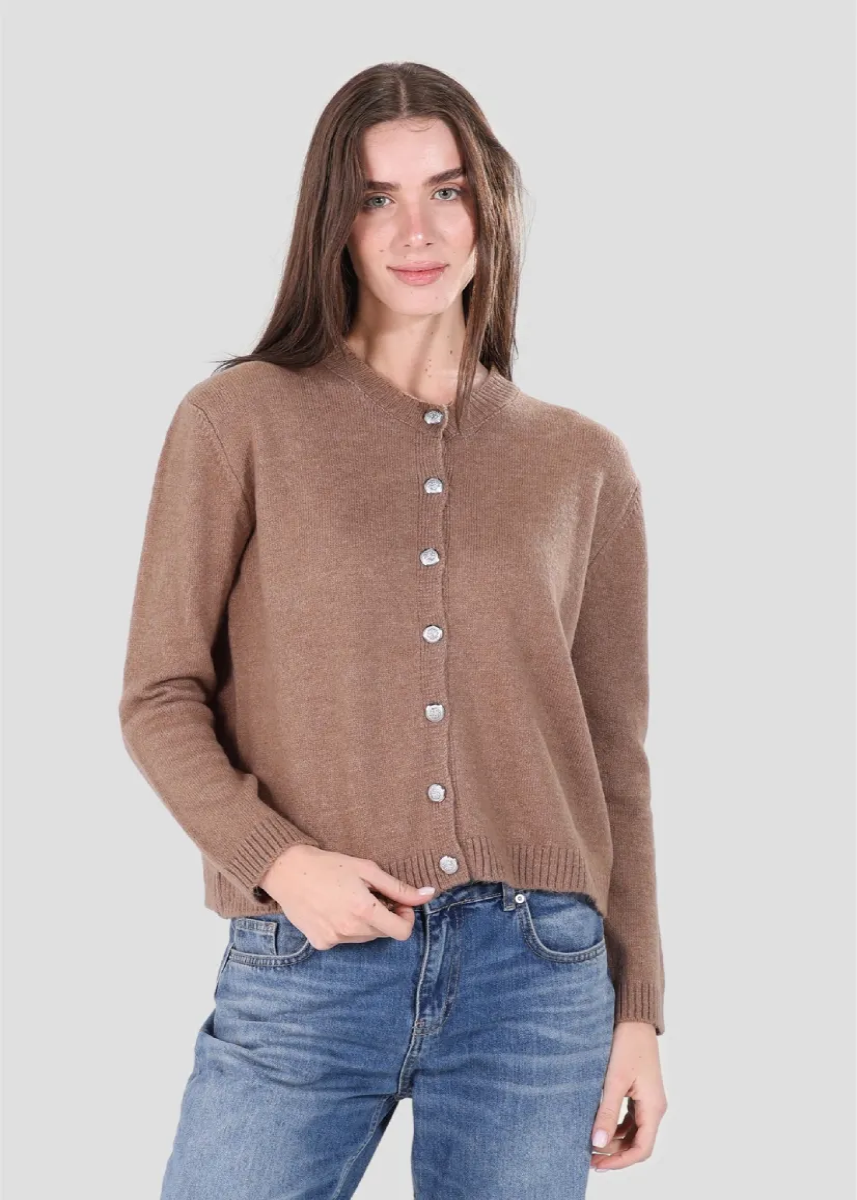 Woman wearing a brown cardigan and blue jeans on a white background